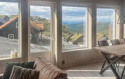 a dining room with a table and large windows at Awesome Home In Rauland in Rauland