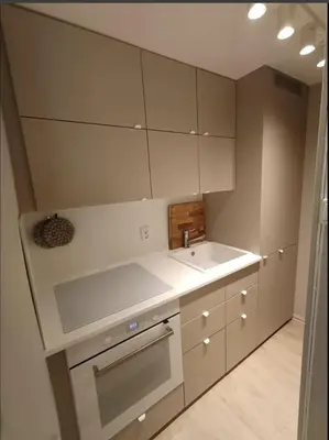 a small kitchen with white cabinets and a sink at Ytre Markveien 37 in Bergen