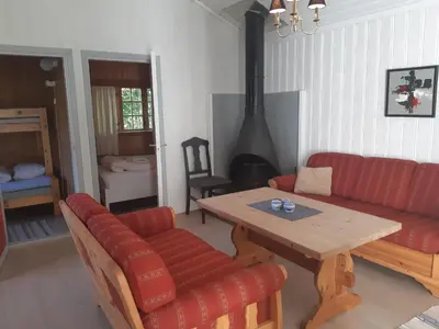a living room with a red couch and a wooden table at Eidsdal Camping og Feriehus in Eidsdal