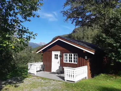 a small cabin with a porch and a deck at Eidsdal Camping og Feriehus in Eidsdal