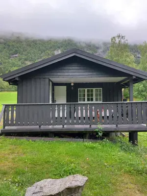 a small cabin with a fence in front of it at Eidsdal Camping og Feriehus in Eidsdal
