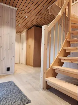 a room with a wooden staircase in a house at Nyoppført hytte med mulighet til å leie badestamp in Levanger