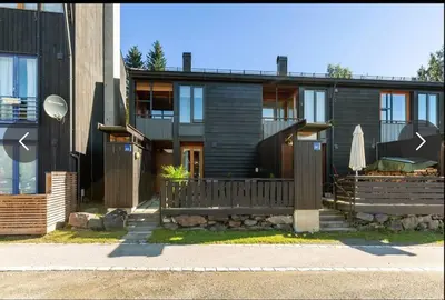 a house with a wooden fence and a umbrella at Delikat og moderne rekkehus in Lillehammer