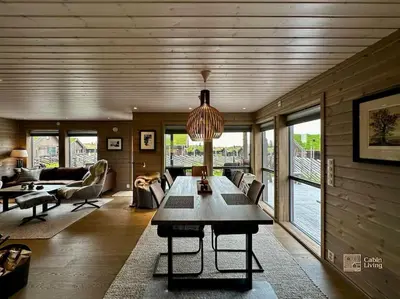 a living room with a table in the middle of it at High standard cabin at Sjusjøen sauna, hot tub & ski trails right outside in Ringsaker