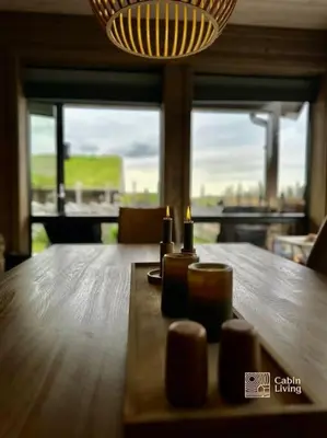 a wooden table with two candles on top of it at High standard cabin at Sjusjøen sauna, hot tub & ski trails right outside in Ringsaker