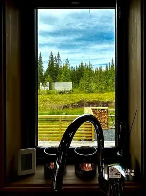 a kitchen sink with a window looking out at a field at High standard cabin at Sjusjøen sauna, hot tub & ski trails right outside in Ringsaker