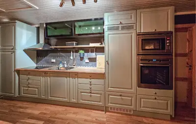 a kitchen with white cabinets and a sink and a refrigerator at 3 Bedroom Nice Home In Tuddal in Tuddal