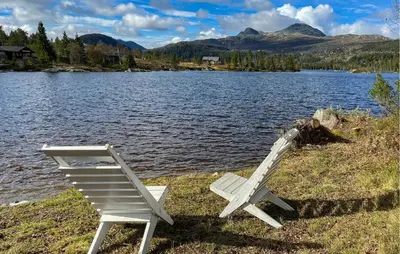 two chairs sitting on the shore of a lake at 3 Bedroom Nice Home In Tuddal in Tuddal
