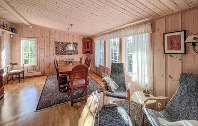 a living room with a wooden table and chairs at Stunning Home In Sjusjøen With Sauna in Sjusjøen