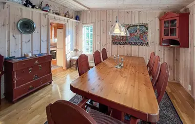 a dining room with a wooden table and chairs at Stunning Home In Sjusjøen With Sauna in Sjusjøen