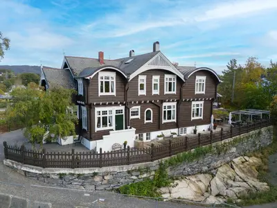 a large wooden house with a fence at Jervell 4 Bnb in Ålesund