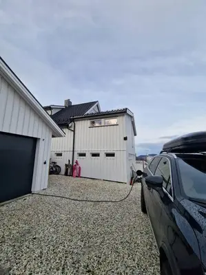 a car parked in a driveway next to a garage at Ski VM 2025 Hus 20 min til Granåsen og trdh in Melhus