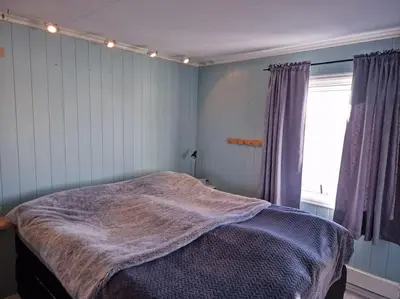 a bedroom with a bed with a blanket on it at Ski VM 2025 Hus 20 min til Granåsen og trdh in Melhus