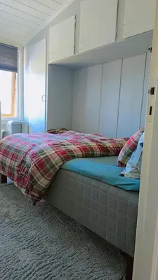 a bedroom with a bed with a plaid blanket at Room In Handsome Haven House in Gjøvik