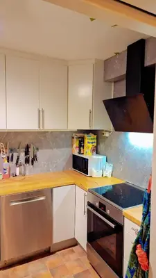 a kitchen with white cabinets and a stove top oven at Room In Handsome Haven House in Gjøvik