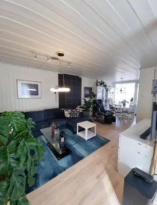 a living room with a blue couch and a table at Room In Handsome Haven House in Gjøvik