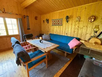 a living room with a blue couch and a table at Granbu by Norgesbooking - cozy cabin at Golsfjellet in Ulnes