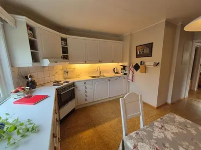 a kitchen with white cabinets and a counter top at Cozy Home with Sauna, river views and 10 min from Hafjell and Lillehammer in Fåberg