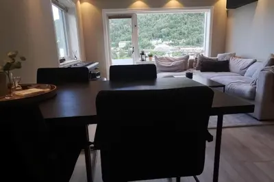 a living room with a table and a couch at Koselig leilighet nær sentrum in Laksevag