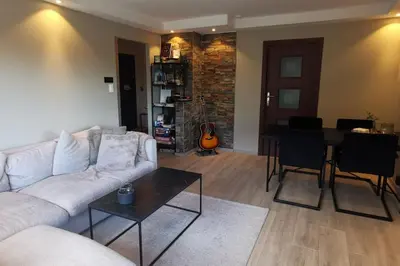 a living room with a white couch and a table at Koselig leilighet nær sentrum in Laksevag