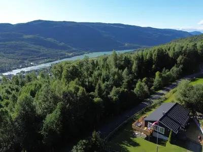 an aerial view of a house with a river and trees at Fantastisk feriehus på Tretten, Hafjell in Tretten
