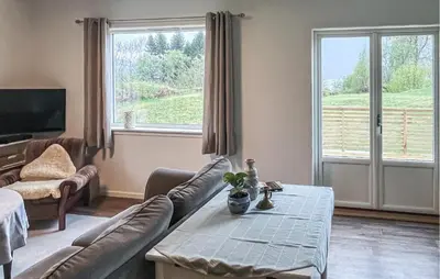 a living room with a couch and a table at Lovely Home In Sørbøvåg in Sørbø