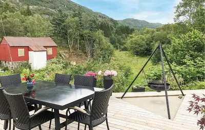 a table and chairs on a deck with a view at Lovely Home In Sørbøvåg in Sørbø