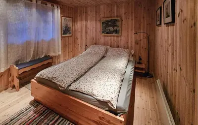 a bedroom with a bed in a wooden room at Gorgeous Home In Tuddal in Tuddal