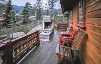 a porch of a cabin with a stone fireplace at Gorgeous Home In Tuddal in Tuddal