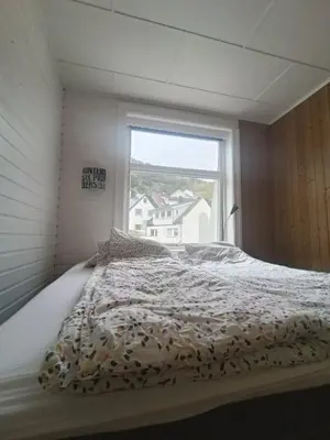 a large bed in a room with a window at Flott leilighet med herlig utsikt in Ålesund