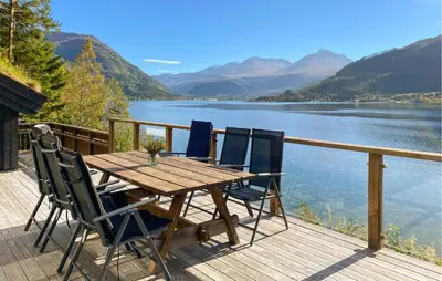 a wooden table and chairs on a deck overlooking a lake at Stunning Home In Todalen in Ålvundfjord