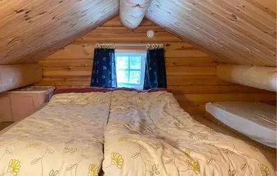 a bed in a log cabin with a window at Stunning Home In Todalen in Ålvundfjord