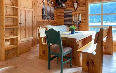 a dining room with a wooden table and chairs at Stunning Home In Todalen in Ålvundfjord