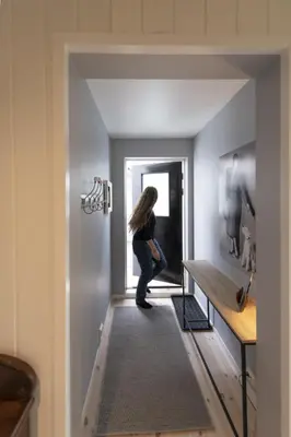a woman standing in the hallway of a house at Koselig leilighet i sentrum in Ålesund