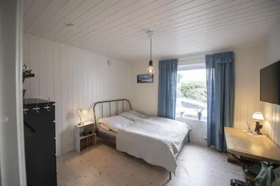 a small bedroom with a bed and a window at Koselig leilighet i sentrum in Ålesund