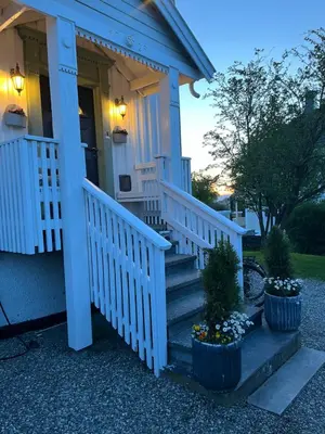 a blue house with stairs and flowers in pots at Villa apartment in Trondheim