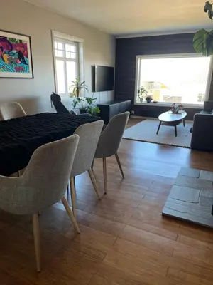 a living room with a dining room table and chairs at Villa apartment in Trondheim