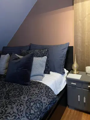 a bed with blue and white pillows in a room at Villa apartment in Trondheim