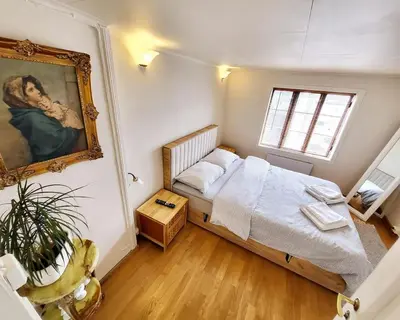 a bedroom with a bed and a painting on the wall at OAH 1870 Oldest Alesund House in Ålesund