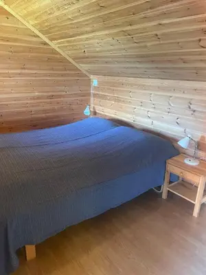 a bed in a room with a wooden wall at Seaside 3-bedroom Holiday home in Balestrand