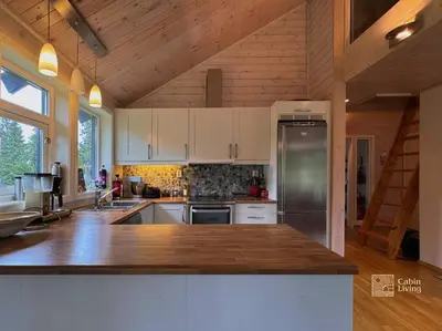 a kitchen with white cabinets and a stainless steel refrigerator at Cabin at Sjusjøen Birkebeiner trail ski in out, 8 beds, 2 bathrooms & Wifi in Sjusjøen
