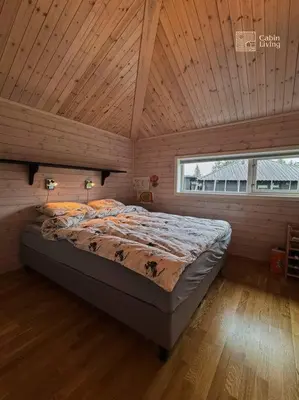 a bed in a room with a wooden ceiling at Cabin at Sjusjøen Birkebeiner trail ski in out, 8 beds, 2 bathrooms & Wifi in Sjusjøen