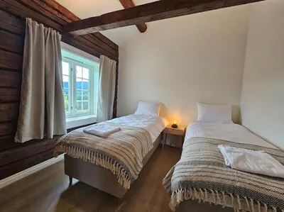 two beds in a room with a window at Stort hus med 2 leiligheter til leie på Lundamo, Perfekt for større grupper! in Melhus