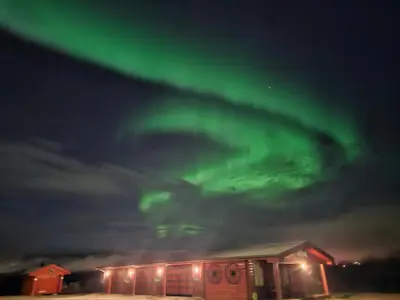 a building with a green aurora in the sky at Stort hus med 2 leiligheter til leie på Lundamo, Perfekt for større grupper! in Melhus