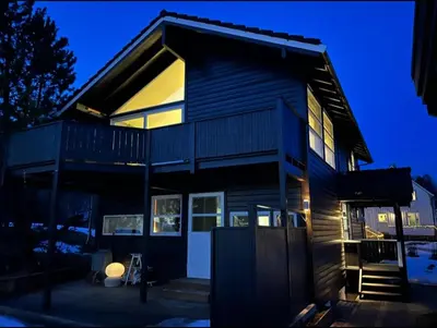 a large house with a lit up facade at night at Hus ski VM 2025 in Trondheim
