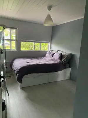 a bedroom with a bed with purple sheets and a window at Hus ski VM 2025 in Trondheim