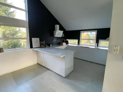 a large kitchen with white cabinets and windows at Hus ski VM 2025 in Trondheim