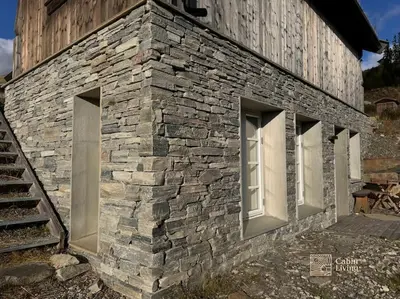 a stone building with two windows and a staircase at Modern apartment with ski in out in Hafjell in Hafjell