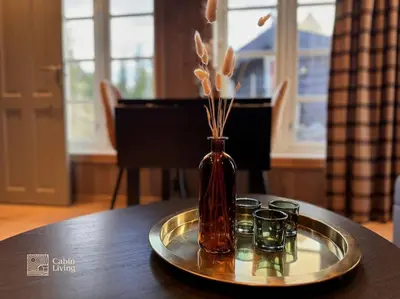 a vase on a tray with three candles on a table at Modern apartment with ski in out in Hafjell in Hafjell