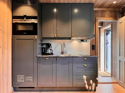 a kitchen with gray cabinets and a sink at Modern apartment with ski in out in Hafjell in Hafjell